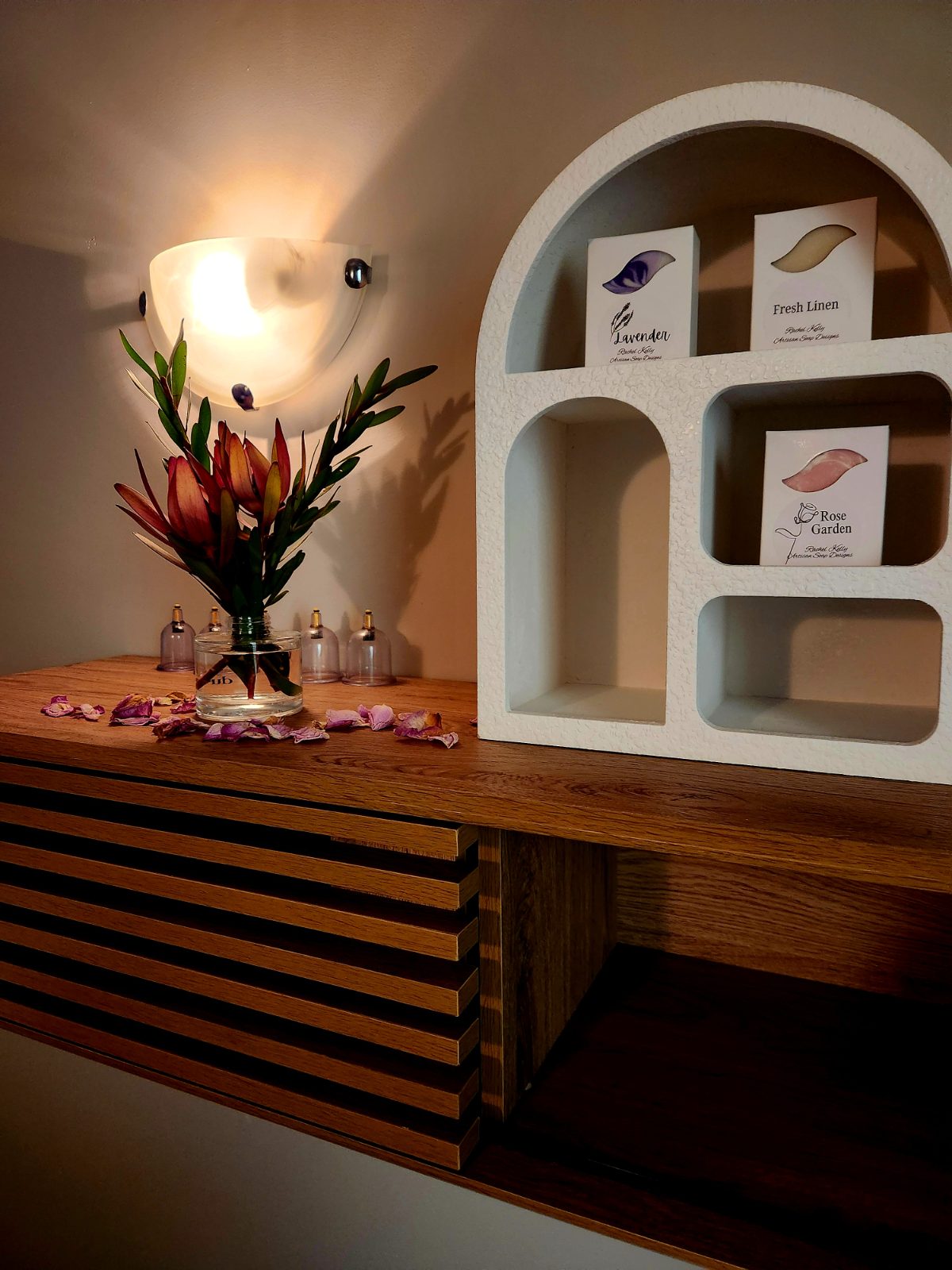 Arched display niche with artisanal botanical soaps and Australian flowers